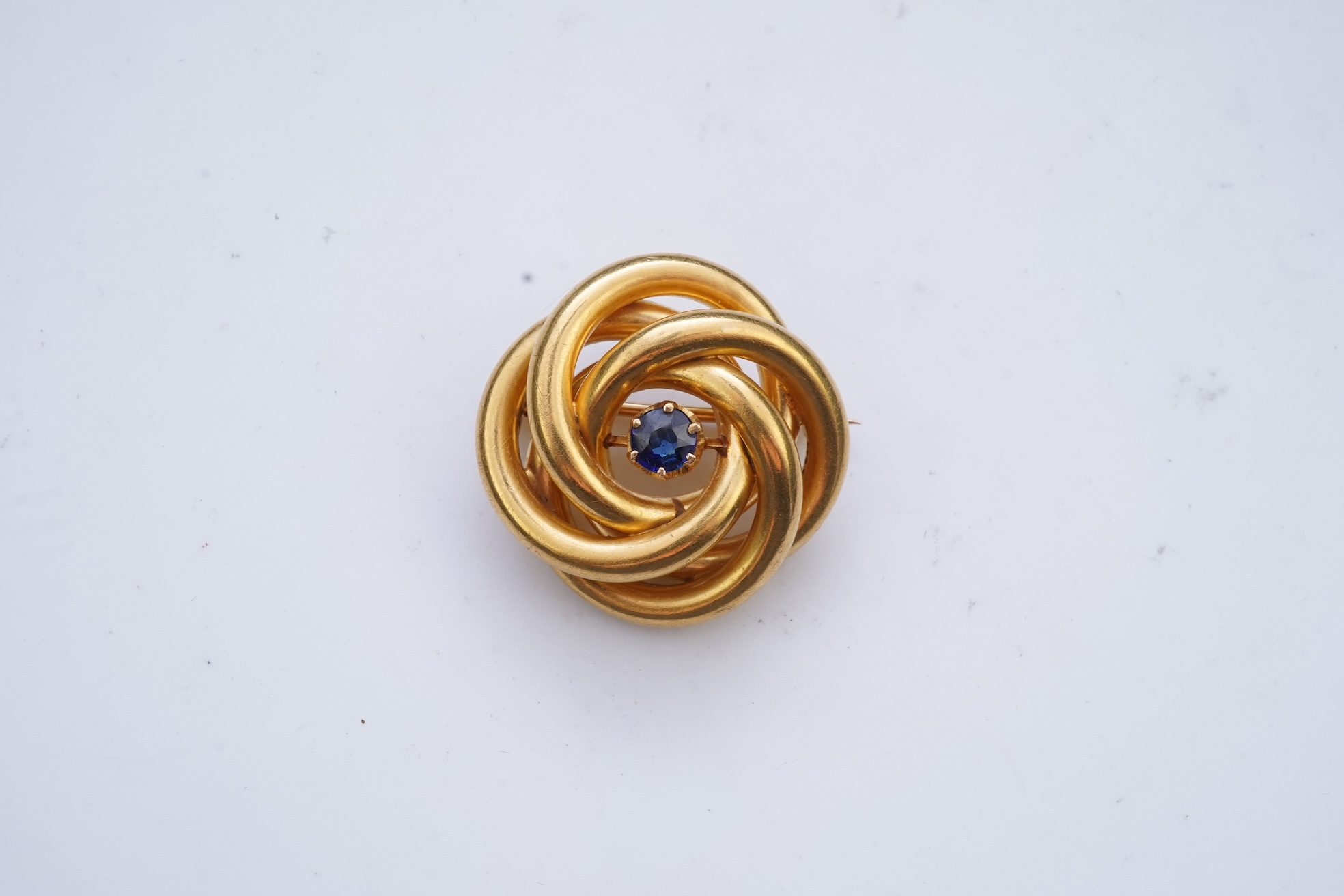 A gold and sapphire knot brooch, France, late 19th century